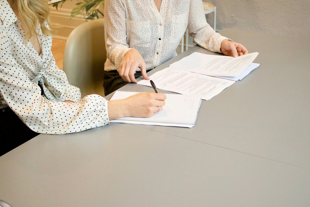 Two colleagues reviewing documents at a table